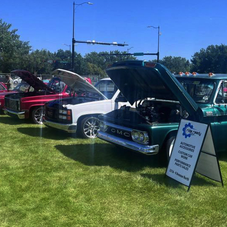 trucks with there hoods open at a car show with a ready ride sign next to the trucks